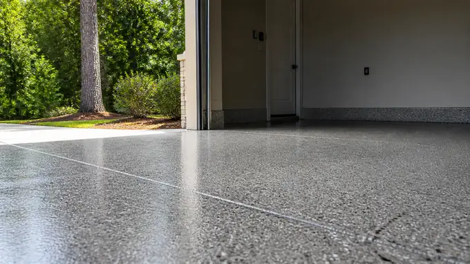 Epoxy-coated garage floor with speckled grey and charcoal flakes in Sandy Springs, GA, in clear late-morning sun.